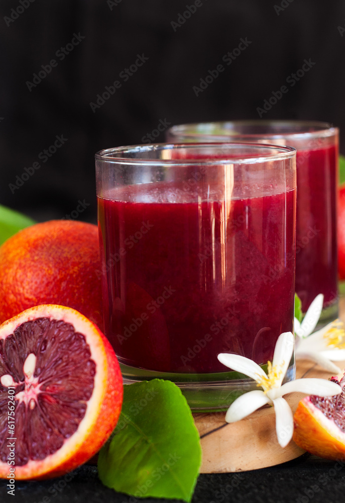 Fresh squeezed blood orange juice decorated with orange blossom. Low key photo. Fresh squeezed blood orange juice decorated with orange blossom. Low key photo.