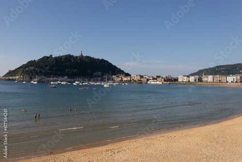 sandy beach shore with blue sea in the bay with mountain in the background in Spain © Maria de la Pe/a