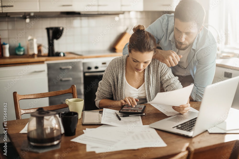 Young couple going over their bills at home in the kitchen Young couple going over their bills at home in the kitchen