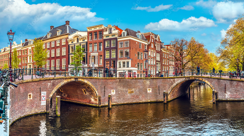 Channel in Amsterdam Netherlands Holland houses under river Amstel. Landmark old european city spring landscape.