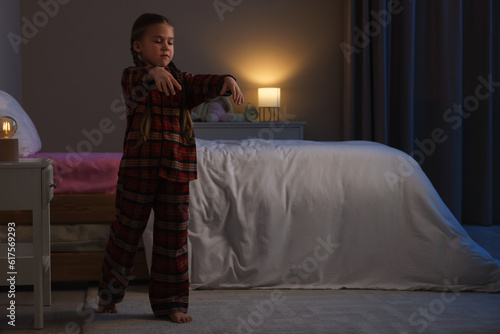 Foto Girl in pajamas sleepwalking indoors at night