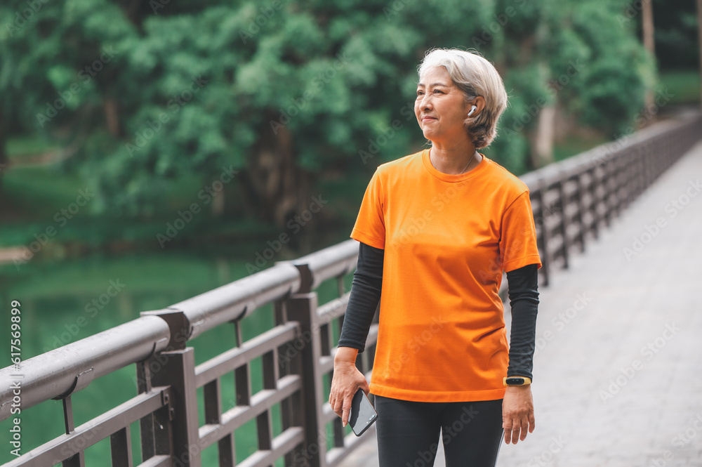 white-haired elderly person exercising in the park early in the morning. white-haired elderly person exercising in the park early in the morning.