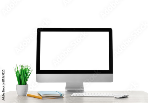 Computer, potted plant and notebook on table against white background. Stylish workplace