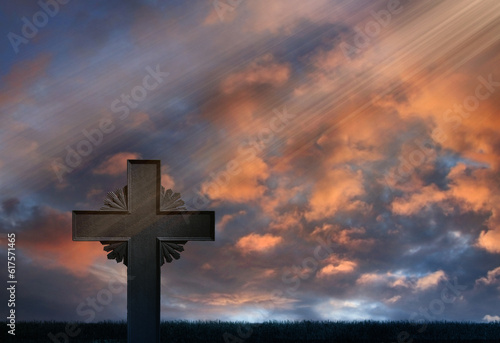 Iron cross standing in front of sunset rays evening sky