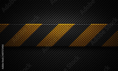 Abstract modern black perforated plate textured material design with warning tape of yellow carbon fiber in center for background, wallpaper, graphic design