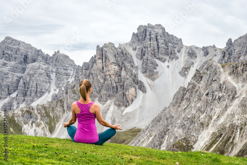 young woman on top of the mountain meditate
