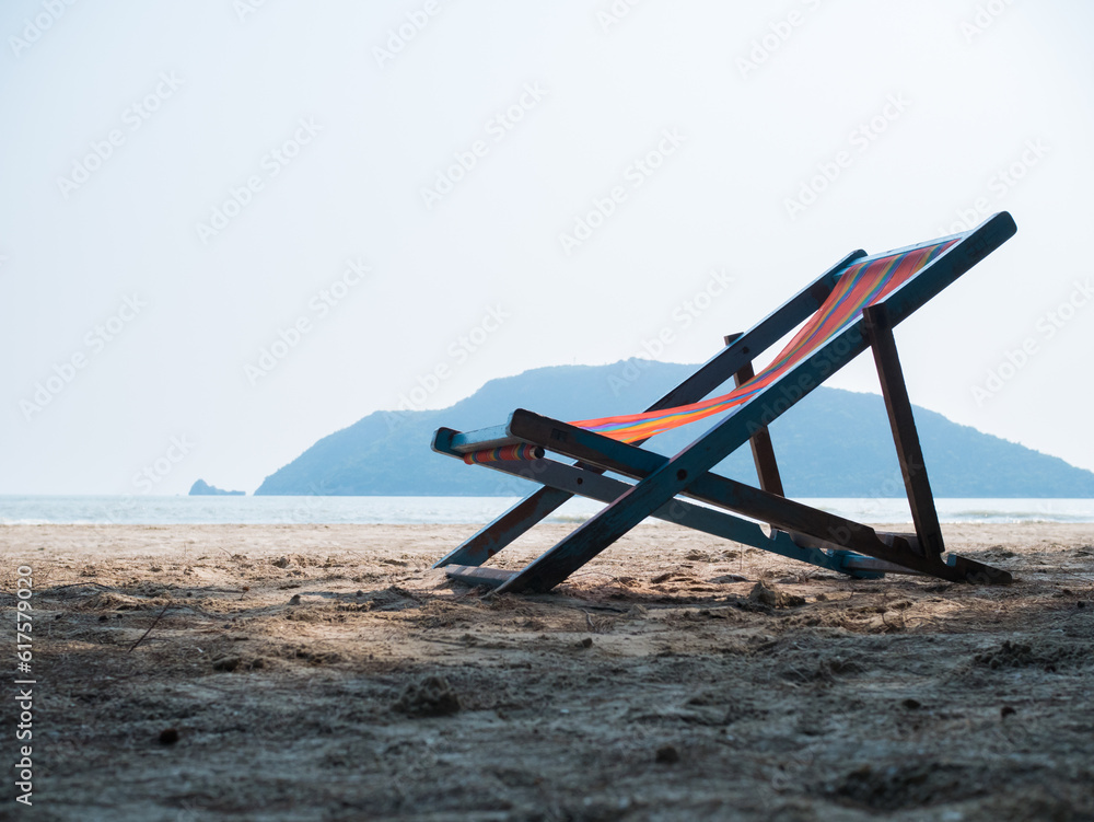Deck chair on sandy beach during day