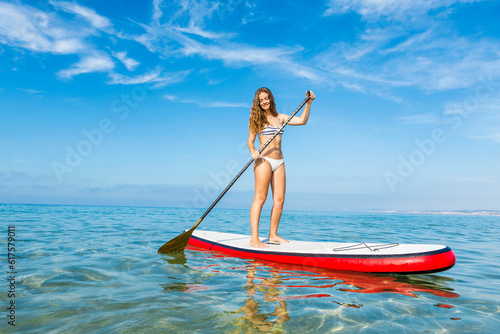 A beautiful woman practicing paddle on a beautiful sunny day © Designpics