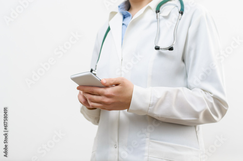 A female doctor texting on smartphone in medical office