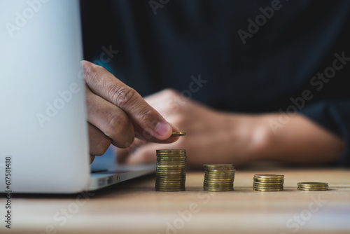 Money saving and finance concept. Businessman using hand stack money on a wooden table. He saving the money for the future, education, investment and retirement.