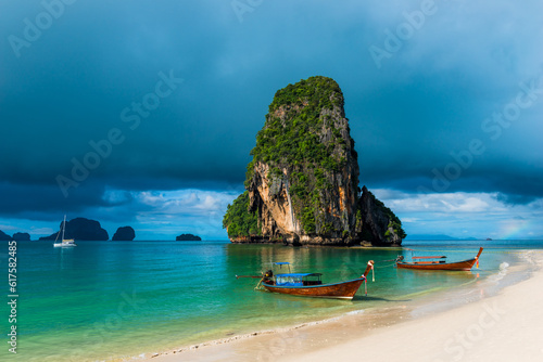 high rock in the sea, rain cloud and Thai boats near the shore © Designpics