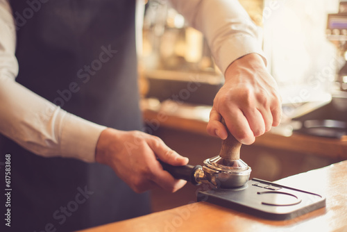 Close up of professional barista. Man making espresso with coffee grain