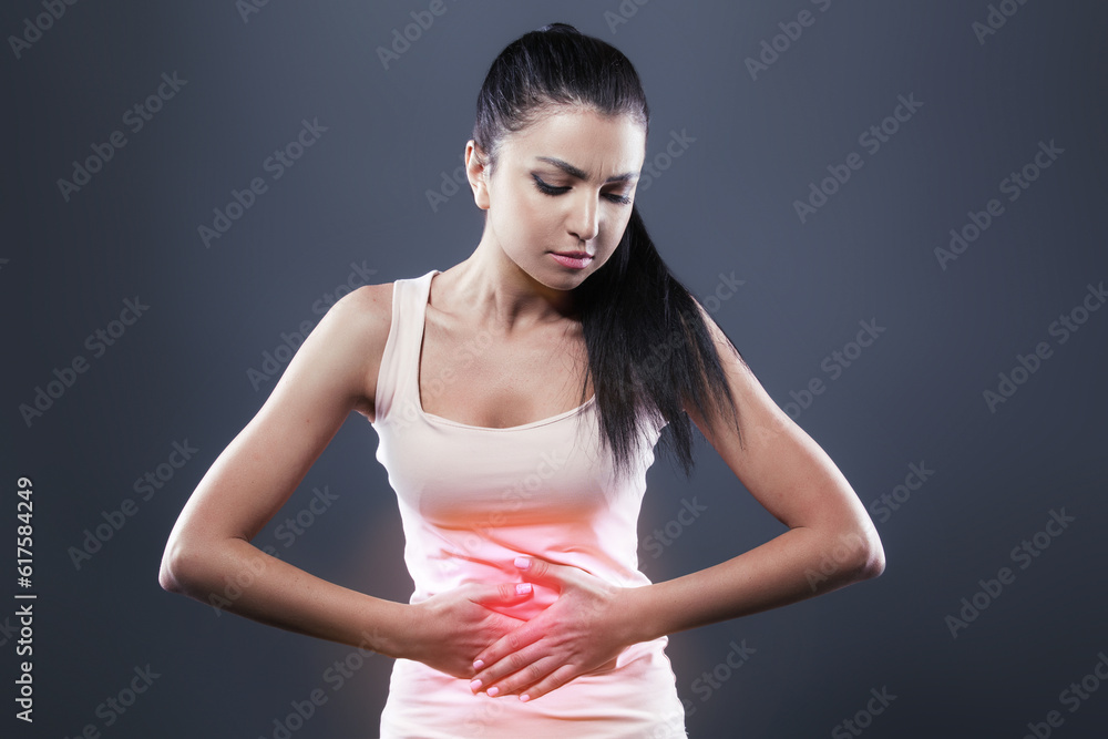 Body pain. Studio shot of beautiful young woman with dark brown hair