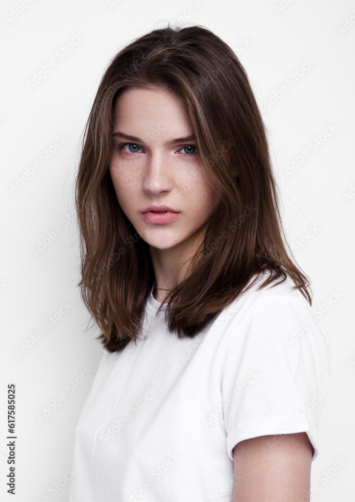Model test portrait with young beautiful fashion model posing on grey background. Wearing white t-shirt. Classic portrait. Model test portrait with young beautiful fashion model posing on grey background. Wearing white t-shirt. Classic portrait.