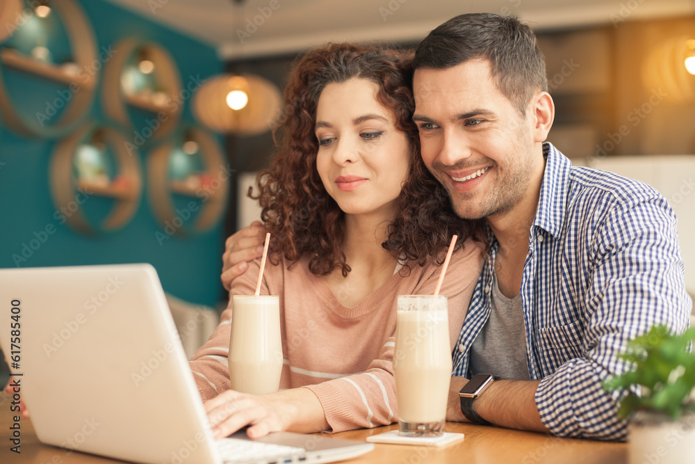 Date in cafe. Lovely couple in cafe with stylish interior. Man and woman having delicious coffee drinks. They chatting, using laptop and smiling Date in cafe. Lovely couple in cafe with stylish interior. Man and woman having delicious coffee drinks. They chatting, using laptop and smiling