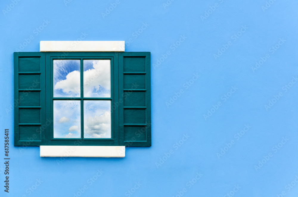 Sky and cloud reflection in green window glass on blue wall of house, Italy retro style Sky and cloud reflection in green window glass on blue wall of house, Italy retro style