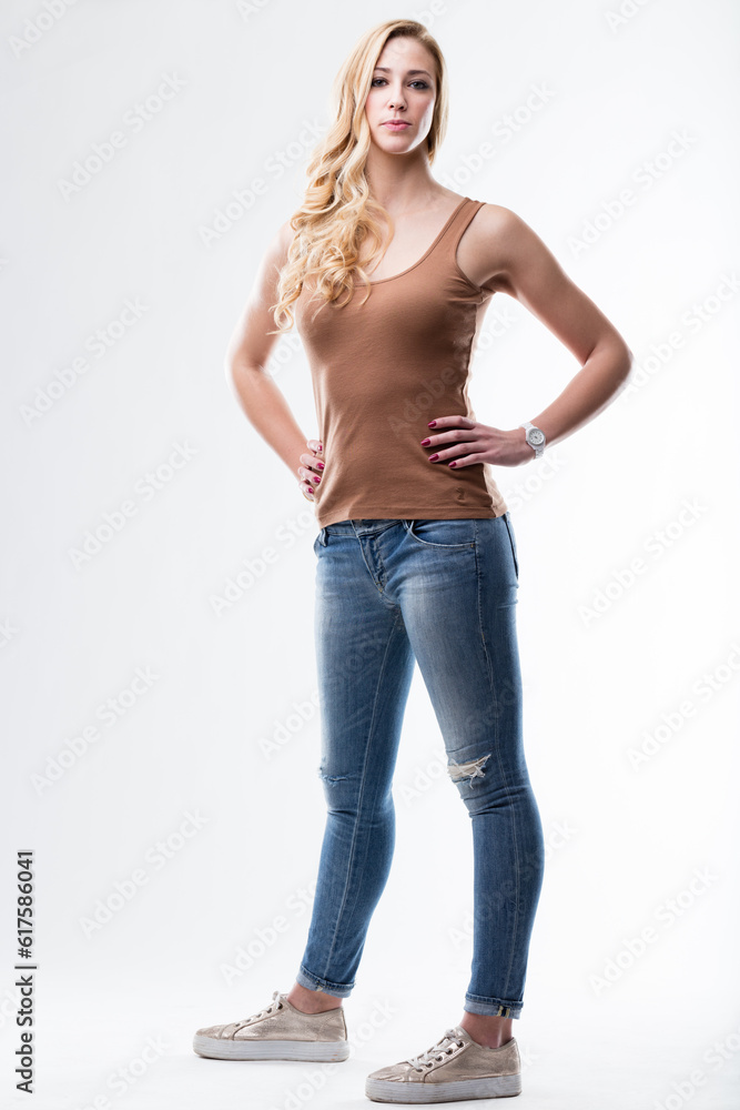 full shot studio portrait of a blonde woman standing dressed in blue jeans and a brown underskirt full shot studio portrait of a blonde woman standing dressed in blue jeans and a brown underskirt