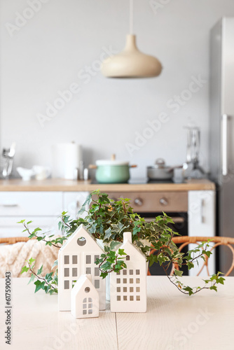 Table with stylish decor and houseplant in light kitchen, closeup