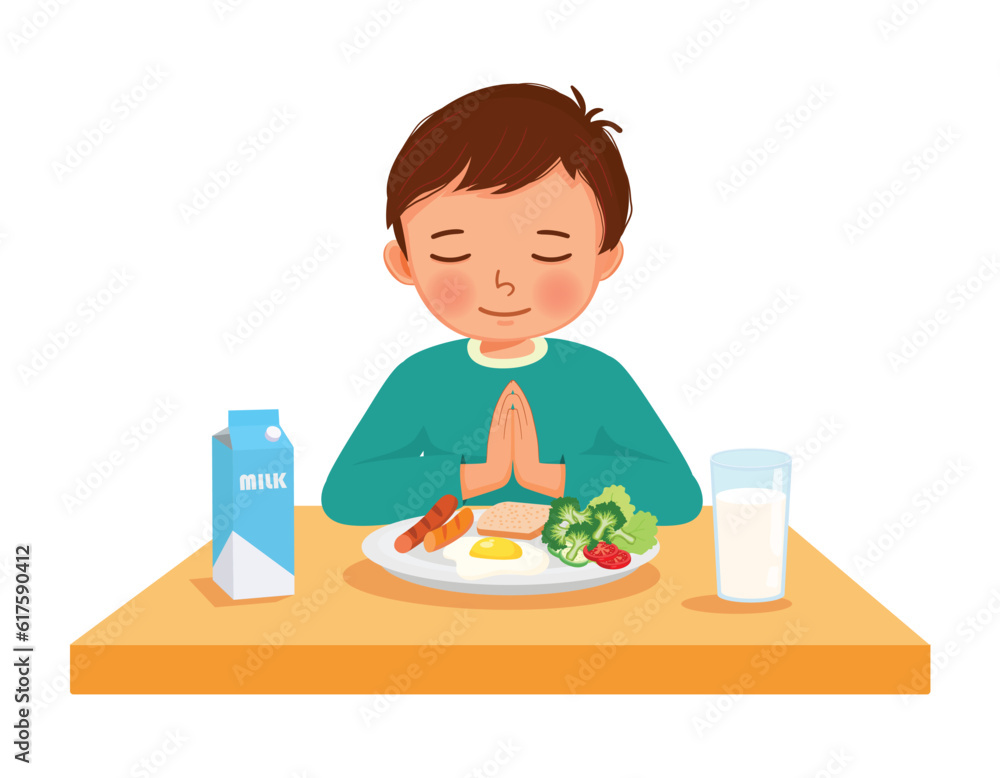 little boy praying before eating breakfast at the table little boy praying before eating breakfast at the table