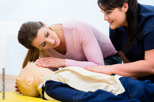 Group of women in first aid class exercising reanimation at model photo