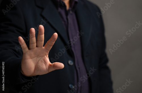 the concept of rejection. Man showing stop rejection gesture on black background with space for text.