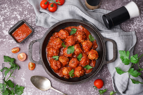 Obraz na plátně Frying pan of tasty meat balls with tomato sauce and parsley on grey background