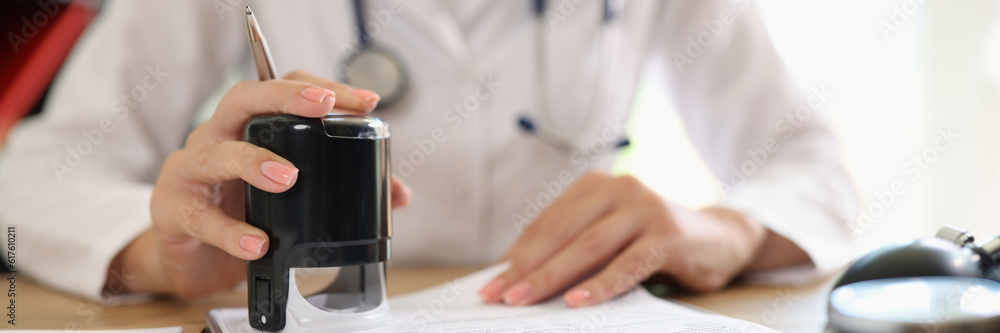 Female doctor putting stamp on medical documents or prescription Female doctor putting stamp on medical documents or prescription