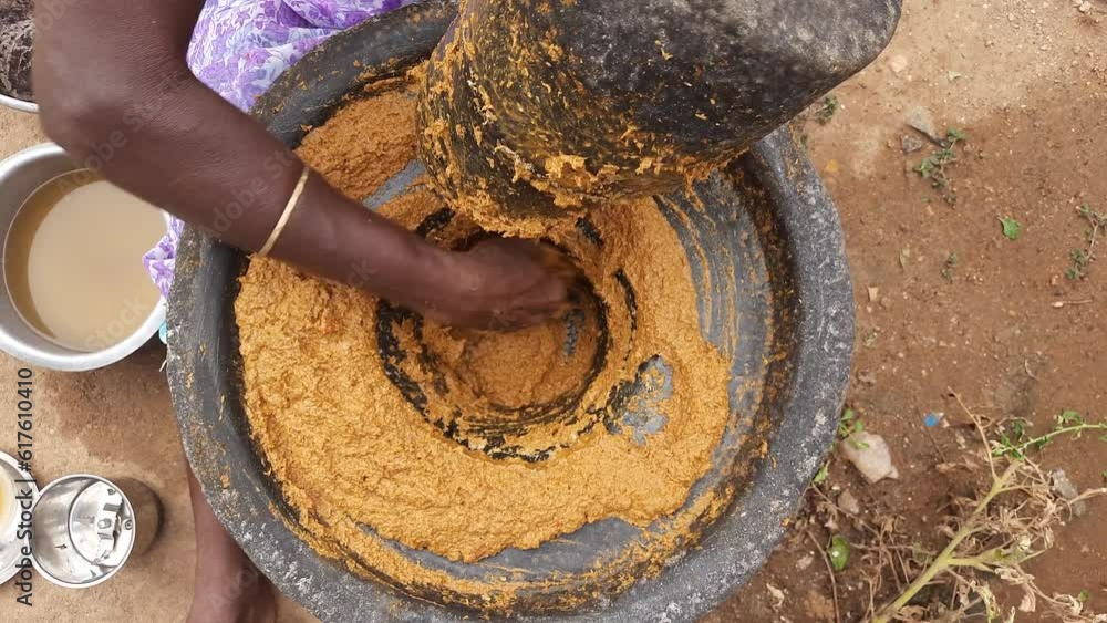 Hand using a large authentic millstone, medieval utensil for grinding masala paste and cereals into flour. Hand using a large authentic millstone, medieval utensil for grinding masala paste and cereals into flour.