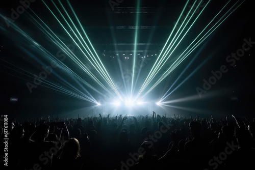 Panorama live music concert crowd and audience with beams light show and concert lighting. Edm electronic techno music festival or rock show performance with crowded people silhouette