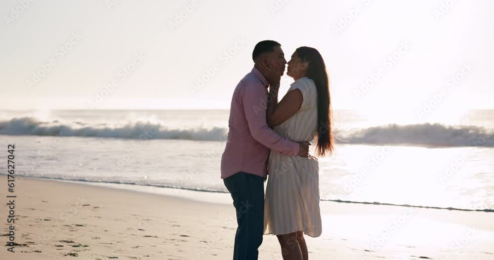 Beach, kiss and couple hug at sunset at the ocean for travel, fun and