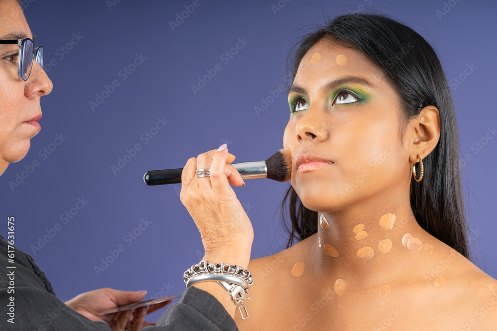 Obraz premium Applying foundation to young model