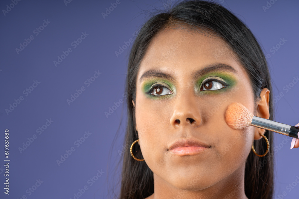 Young woman applying blush with a brush Young woman applying blush with a brush