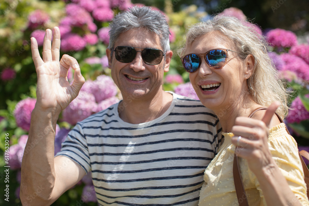 cheerful young and middle aged couple showing thumb-up cheerful young and middle aged couple showing thumb-up