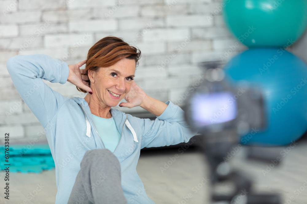 Fototapeta premium young female blogger recording sports video at home