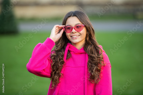 smiling fashion teen girl outside. fashion teen girl wear glasses.