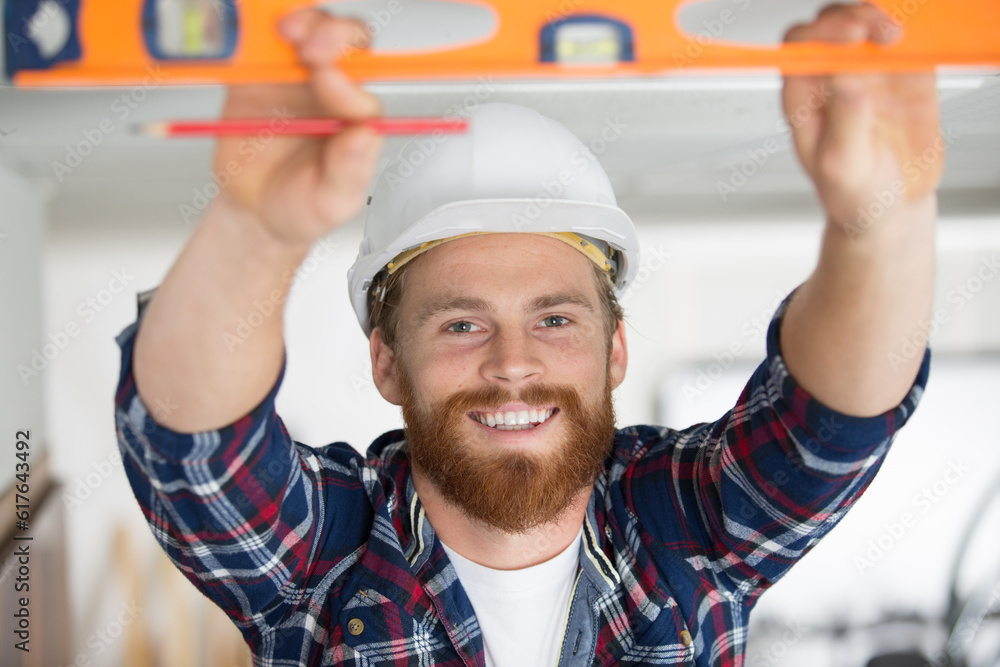 happy man taking measures with spirit level happy man taking measures with spirit level