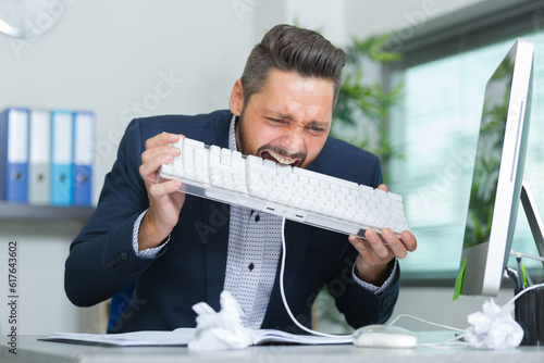 man eats a keyboard in rage