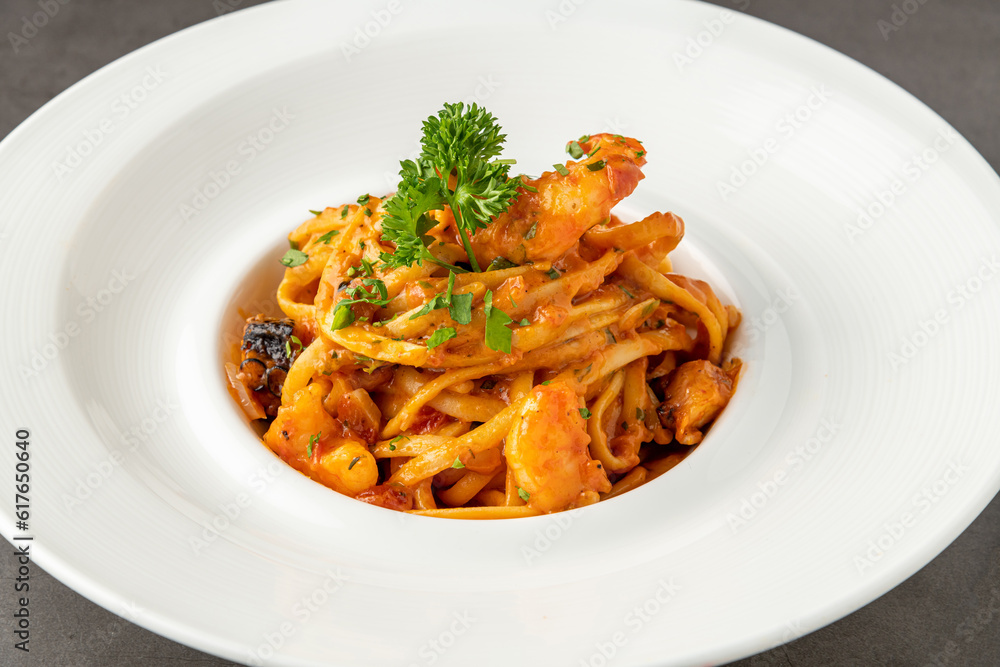 Shrimp spaghetti on white porcelain plate on black stone table Shrimp spaghetti on white porcelain plate on black stone table