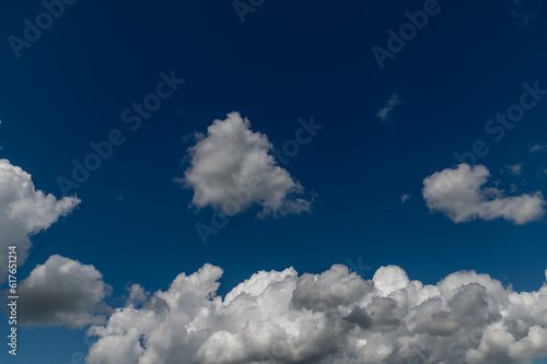 Stormy and fluffy white and grey clouds against a bright blue sky
