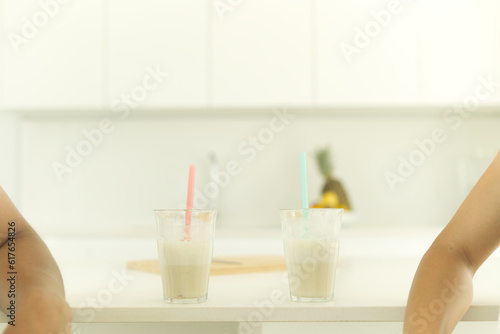 Two glasses of protein shakes sit on the kitchen counter.
