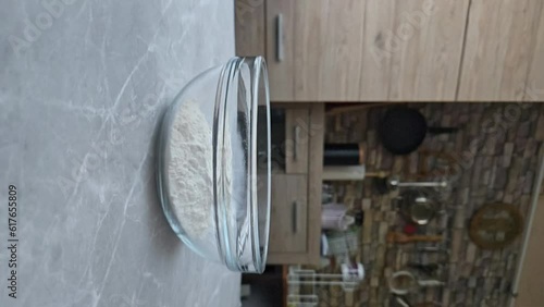 Egg falling into transparent bowl with all purpose flour photo