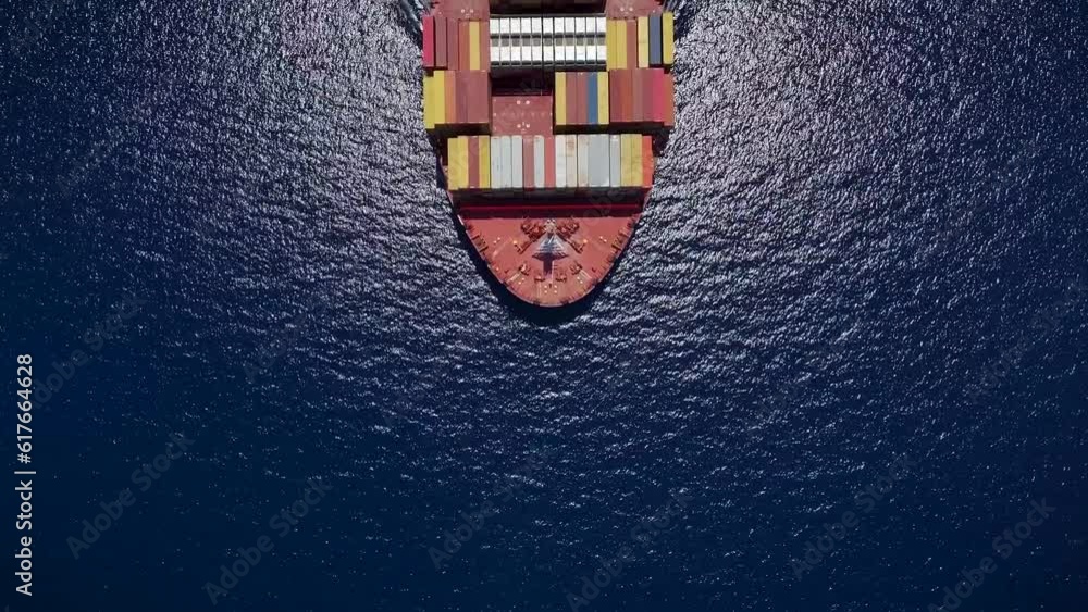 Aerial top down view of a large container cargo ship crossing the sea with speed Aerial top down view of a large container cargo ship crossing the sea with speed