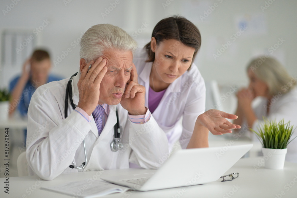 Male doctor sitting at table in clinic Male doctor sitting at table in clinic
