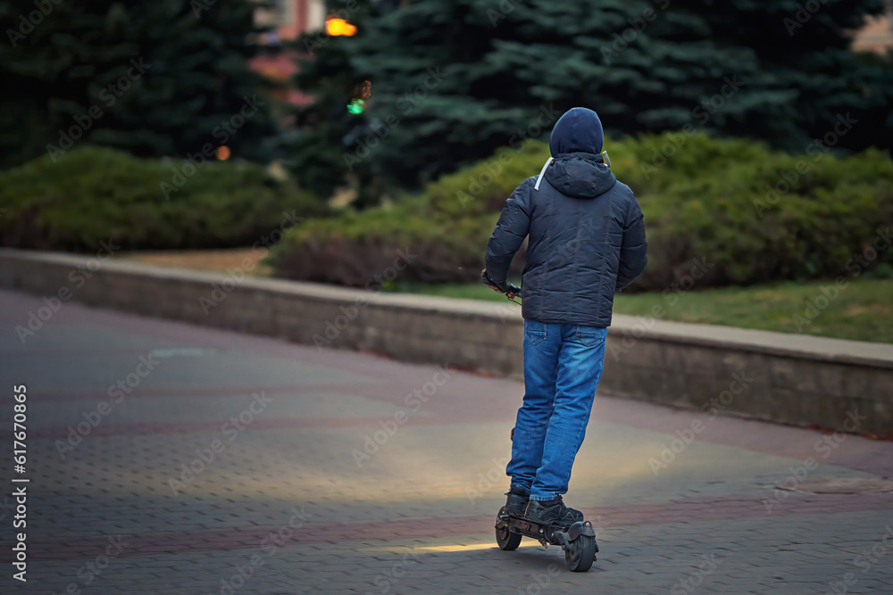 Man ride on electric scooter with led headlight at evening city. Night riding on scooter with bright headlight. Electric scooter with headlights.