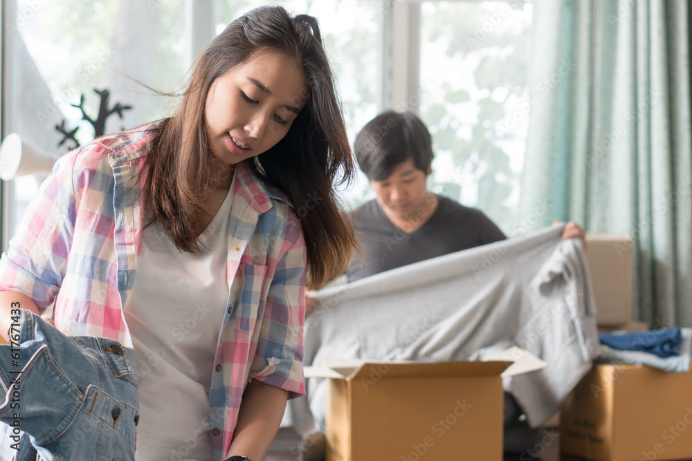 Concept young couple moving house. Asian young couple unpack cardboard box after moving in new house. Concept young couple moving house. Asian young couple unpack cardboard box after moving in new house.