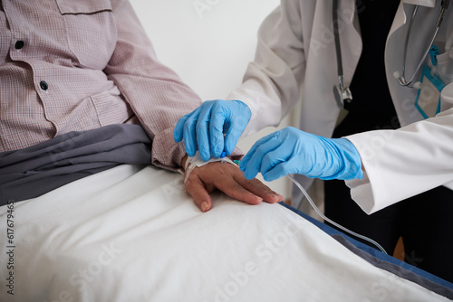 Closep image of doctor in medical gloves inserting IV catheter photo