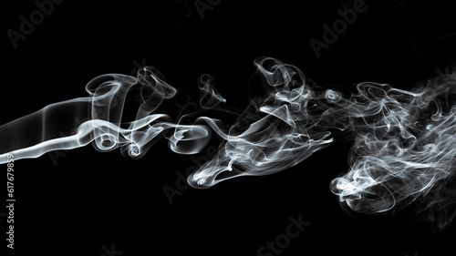 Use your imagination and dream on. Studio close up monochrome pictures of incense stick smoke and hard directional light on black background