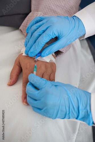 Hands of doctor removing intravenous catheter after finishing medical procedure