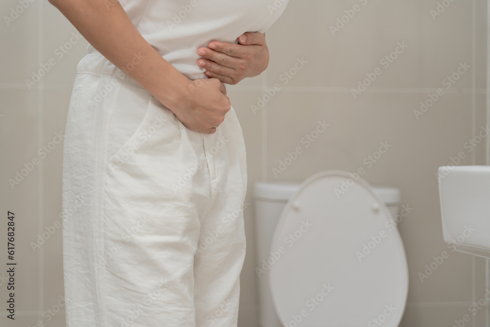 Constipation and diarrhea in bathroom. Hurt woman touch belly stomach