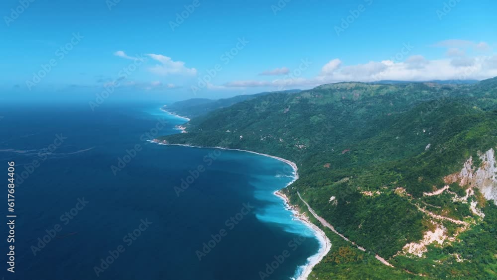Picturesque ocean bay with blue water near the green tropical mountainous peninsula. Stunning natural aerial view with mountain ending on the beach. Fly around the mountain with forest trees. Picturesque ocean bay with blue water near the green tropical mountainous peninsula. Stunning natural aerial view with mountain ending on the beach. Fly around the mountain with forest trees.
